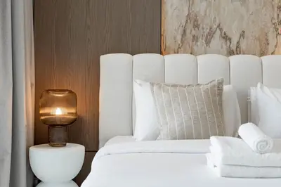 a bedroom with a white bed and a lamp at Private pool, Paddle court, Sauna and Hammam - Binghatti Royal in Dubai