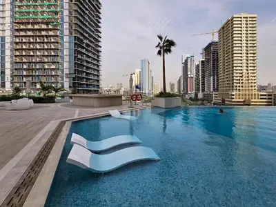 a swimming pool in a city with tall buildings at Private pool, Paddle court, Sauna and Hammam - Binghatti Royal in Dubai