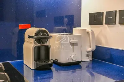 a coffee machine sitting on top of a blue counter at Stylish Studio with views of pool & Burj Khalifa in Dubai