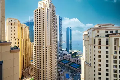 a tall building with a clock on top of it at Stunning 2BR with Sea View Murjan 1 Near Beach in Dubai