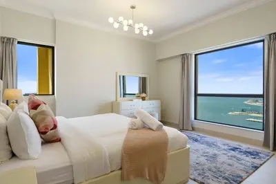 a bedroom with a large bed and a large window at Modern Upgraded 1BR - High Floor with Ocean View in Dubai