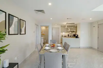 a dining room and kitchen with a table and chairs at Modern Upgraded 1BR - High Floor with Ocean View in Dubai