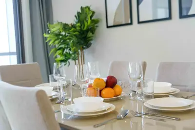 a dining room table with glasses and fruit on it at Modern Upgraded 1BR - High Floor with Ocean View in Dubai