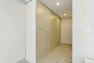 a walk in closet with white walls and white cabinets at Modern Upgraded 1BR - High Floor with Ocean View in Dubai