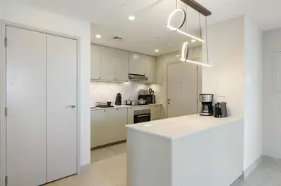 a kitchen with white cabinets and a white counter top at Modern Upgraded 1BR - High Floor with Ocean View in Dubai