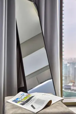 a book sitting on a desk next to a window at Frank Porter - Peninsula One in Dubai