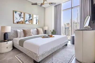 a bedroom with a large white bed and a large window at Frank Porter - Peninsula One in Dubai