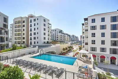 an apartment patio with a swimming pool and buildings at Frank Porter - La Voile 3, La Mer in Dubai