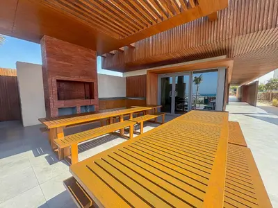 a group of wooden benches sitting on a patio at Frank Porter - La Voile 3, La Mer in Dubai