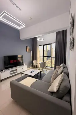 a living room with a couch and a tv at 1BR in Dubai Marina with Marina Skyline Views in Dubai