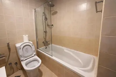 a bathroom with a shower and a toilet and a tub at 1BR in Dubai Marina with Marina Skyline Views in Dubai