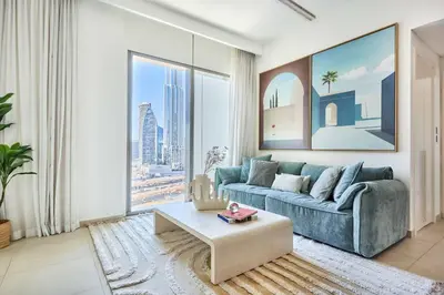 a living room with a blue couch and a large window at Frank Porter - Downtown Views II in Dubai