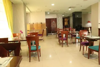 a restaurant with wooden tables and chairs and a unintention at Al Manar Grand Hotel Apartment in Dubai