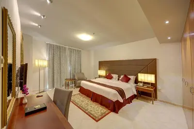 a hotel room with a large bed and a desk at Al Manar Grand Hotel Apartment in Dubai