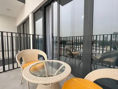 a balcony with chairs and tables and windows at Elegant Retreat Studio in Azizi Mirage in Dubai
