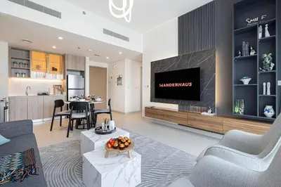 a living room with a tv and a kitchen at Bright & Stylish 1BR in Park Field, Dubai Hills Estate in Dubai
