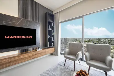 a living room with two chairs and a television at Bright & Stylish 1BR in Park Field, Dubai Hills Estate in Dubai