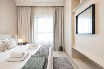 a bedroom with a bed and a large window at Bright & Stylish 1BR in Park Field, Dubai Hills Estate in Dubai