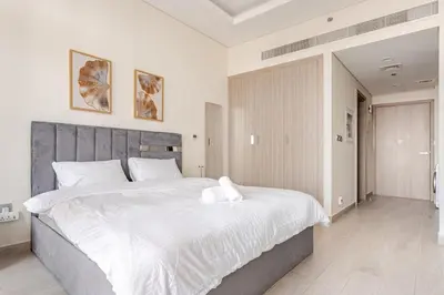 a bedroom with a large bed with white sheets at Stylish Studio near Downtown with pool in Dubai