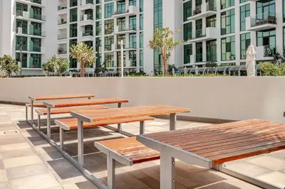 a row of picnic tables in front of a building at Stylish Studio near Downtown with pool in Dubai