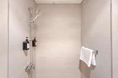 a bathroom with a shower with a glass door at Stylish Studio near Downtown with pool in Dubai