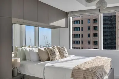 a bedroom with a large white bed with a large window at Stunning 2 Bedroom Apartment in Dubai Marina in Dubai