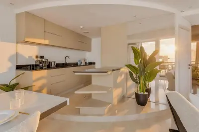a kitchen with white cabinets and a table with a potted plant at Stunning 2 Bedroom Apartment in Dubai Marina in Dubai