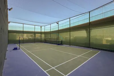 a tennis court with two tennis rackets on it at High-Floor Studio with Views of Miracle Garden and Community, Near Dubai Top Attractions, Skyz by Danube, Arjan by Deluxe Holiday Homes in Dubai