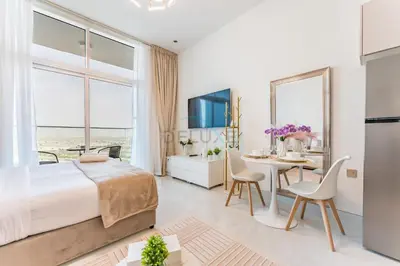 a bedroom with a bed and a table with chairs at High-Floor Studio with Views of Miracle Garden and Community, Near Dubai Top Attractions, Skyz by Danube, Arjan by Deluxe Holiday Homes in Dubai