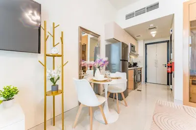 a dining room and kitchen with a table and chairs at High-Floor Studio with Views of Miracle Garden and Community, Near Dubai Top Attractions, Skyz by Danube, Arjan by Deluxe Holiday Homes in Dubai