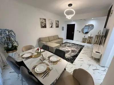 a living room with a table and chairs and a couch at Premium 2BR Marina View Apartment in Dubai Marina in Dubai