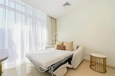 a white bedroom with a bed and a window at Luxury Urban Living at Imperial Avenue, Downtown in Dubai
