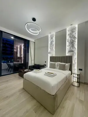 a bedroom with a large bed and a living room at Restay Homes at Oxford Gardens - Great City Escape - Swimming Pool Access in Dubai