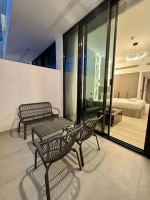 a balcony with two chairs and a table and a bedroom at Restay Homes at Oxford Gardens - Great City Escape - Swimming Pool Access in Dubai
