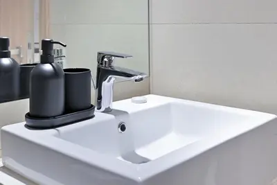 a bathroom sink with a black soap dispenser on it at Bloomfields Cozy 1BR Azizi Riveria 47 in Dubai