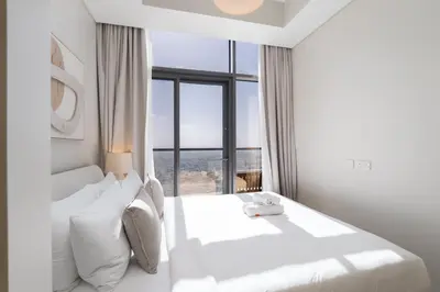a white bedroom with a large bed with a window at StayShort - Elegant 2 BR in Business Bay with Amazing Views that sleeps 5 in Dubai