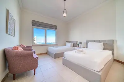 a bedroom with a bed and a couch and a chair at Shoreline 14, Al Hallawi, Palm Jumeirah - Mint Stay in Dubai