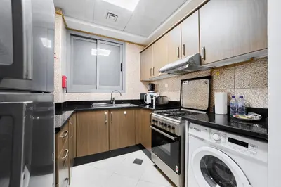 a kitchen with a dishwasher and a washer and sink at Elegant 1BR Apartment in Ikarus, Dubai Production City in Dubai