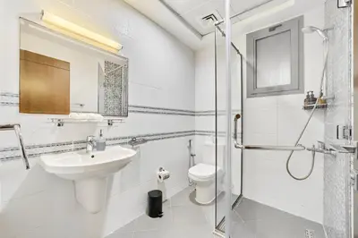 a white bathroom with a sink and a toilet at Elegant 1BR Apartment in Ikarus, Dubai Production City in Dubai