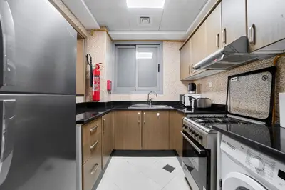 a kitchen with a sink and a stove top oven at Elegant 1BR Apartment in Ikarus, Dubai Production City in Dubai