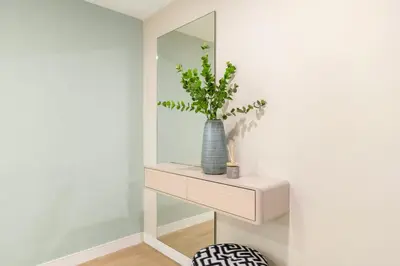 a mirror and a vase with a plant on a shelf at FIRST CLASS 2BR Sea, Palm & Atlantis Views in Dubai