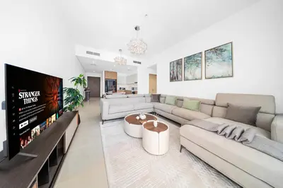 a living room with a couch and a tv at Seagate by Emaar, Mina Rashed Marina, Dubai in Dubai