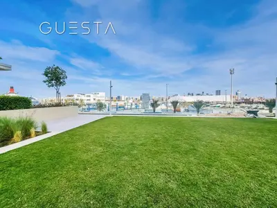 a grassy field with a view of the city at Seagate by Emaar, Mina Rashed Marina, Dubai in Dubai