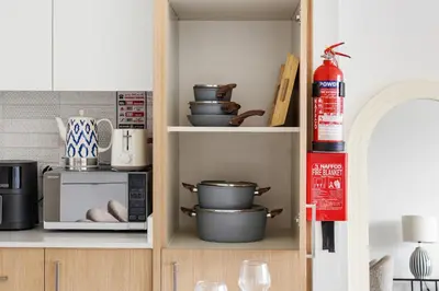 a kitchen with a microwave and some pots and pans at Luxury 2BR with Burj Khalifa View in Port Rashid in Dubai