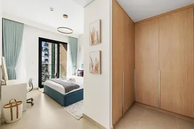 a bedroom with a bed and wooden cabinets at Luxury 2BR with Burj Khalifa View in Port Rashid in Dubai