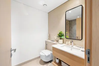 a bathroom with a sink and a toilet and a mirror at Luxury 2BR with Burj Khalifa View in Port Rashid in Dubai