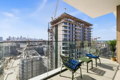 a balcony with chairs and a building under construction at Luxury 2BR with Burj Khalifa View in Port Rashid in Dubai