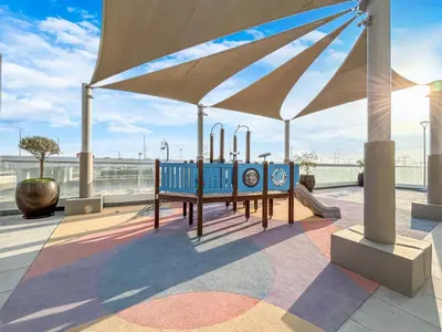 a group of blue benches under a large umbrella at Modern Luxe Studio in the Heart of Meydan in Dubai
