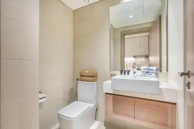 a bathroom with a toilet and a sink and a mirror at Modern Luxe Studio in the Heart of Meydan in Dubai