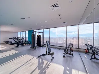 a gym with treadmills and exercise equipment in a building at Modern Luxe Studio in the Heart of Meydan in Dubai
